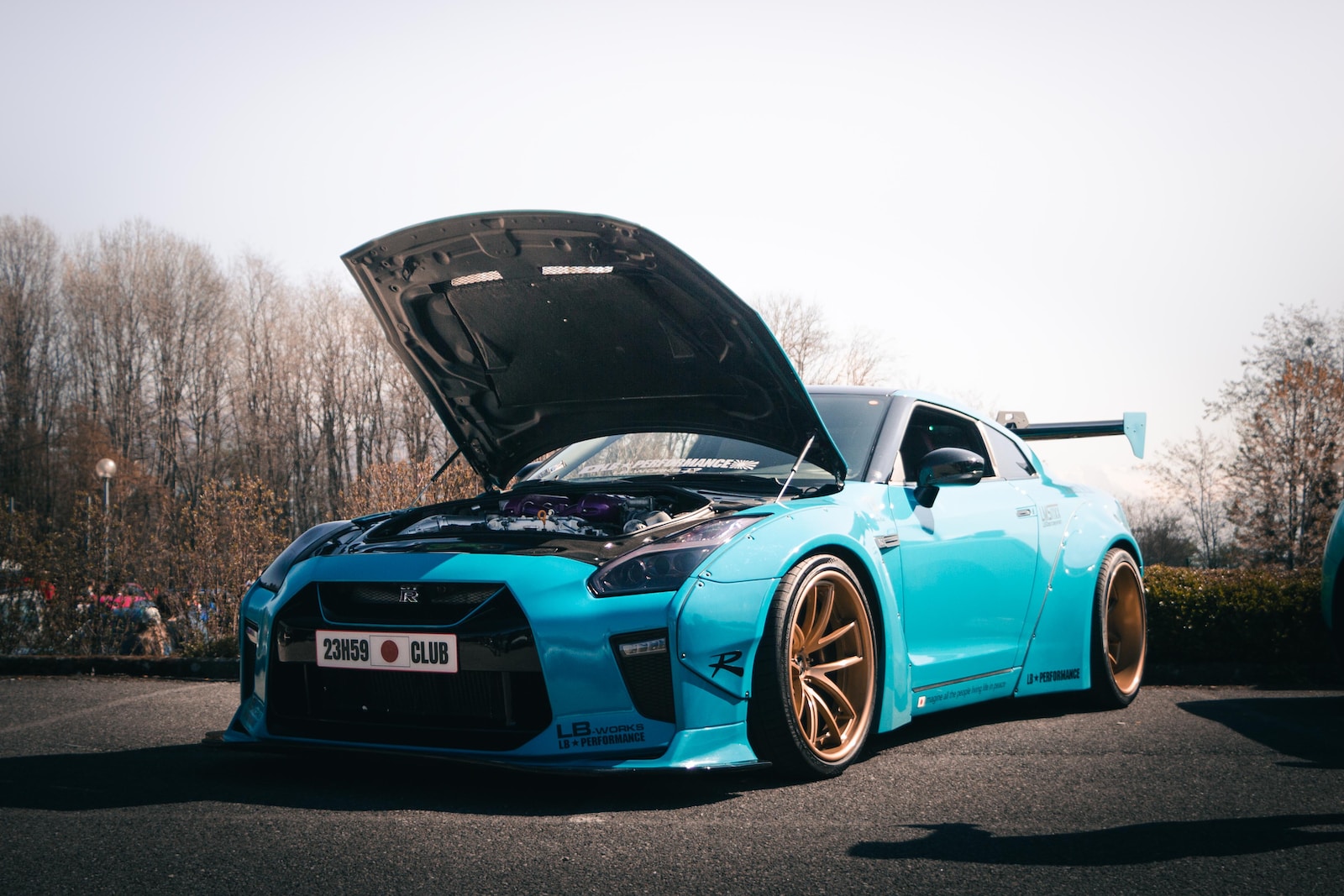 a blue sports car with its hood open