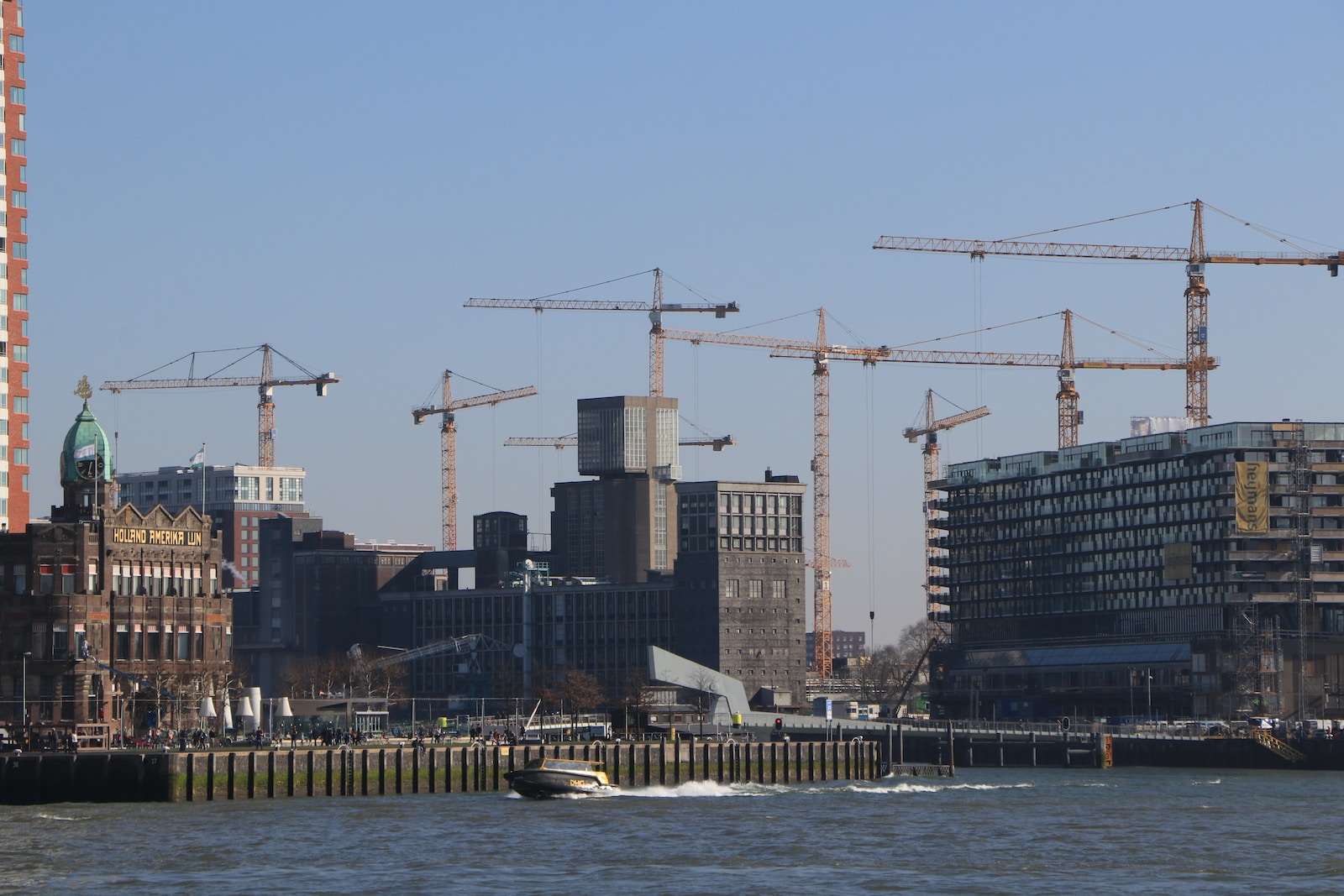 tower cranes beside buildings during daytime